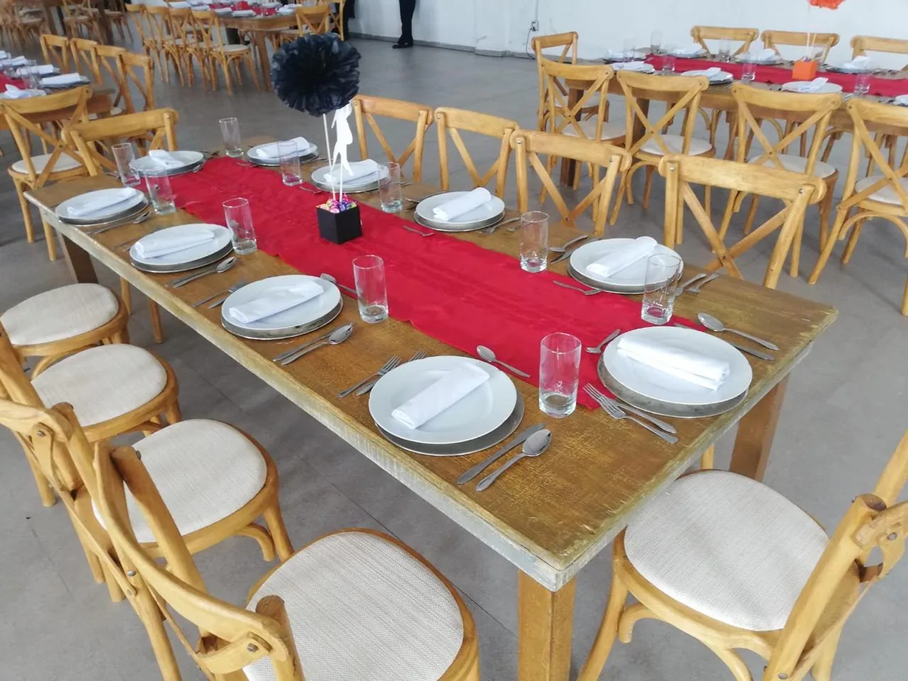 Mesa de madera con camino rojo, vajilla y sillas Cross Back